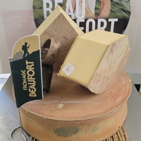 Meule de Beaufort d’été AOP coupée, avec cloche savoyarde, présentée par La Cloche du Fromager