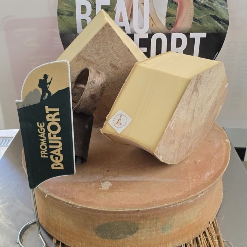 Meule de Beaufort d’été AOP coupée, avec cloche savoyarde, présentée par La Cloche du Fromager